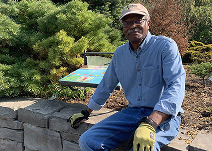 Gregory sitting on a stone wall