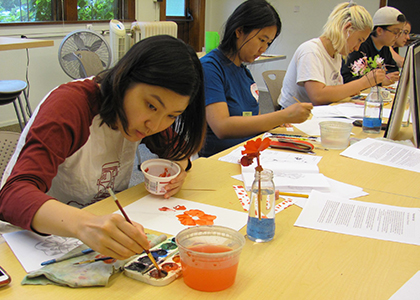 Students sitting at a table painting