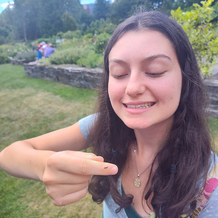Educator looks lovingly at ladybug larva on finger