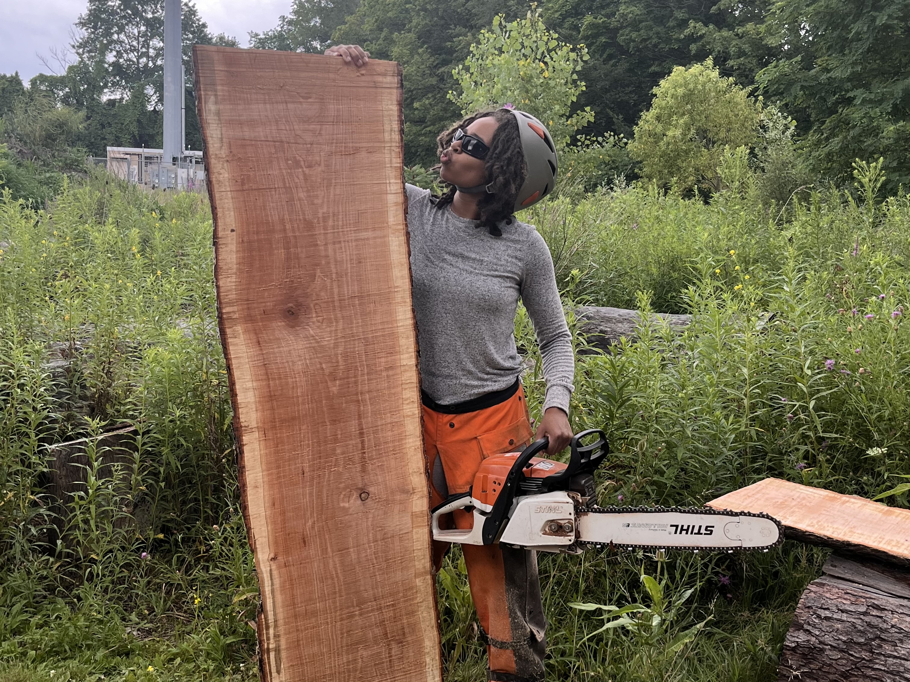 person with a chainsaw and a cut piece of wood