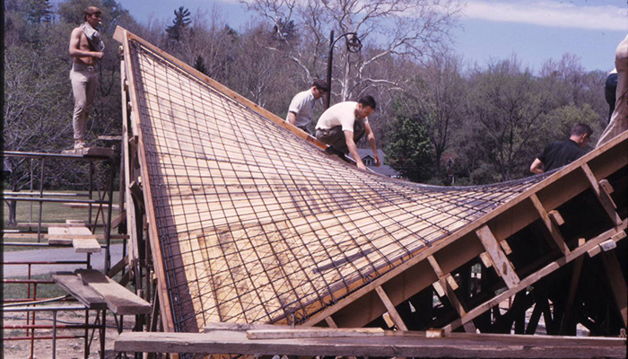 Students building a curvilinear structure in an arboretum