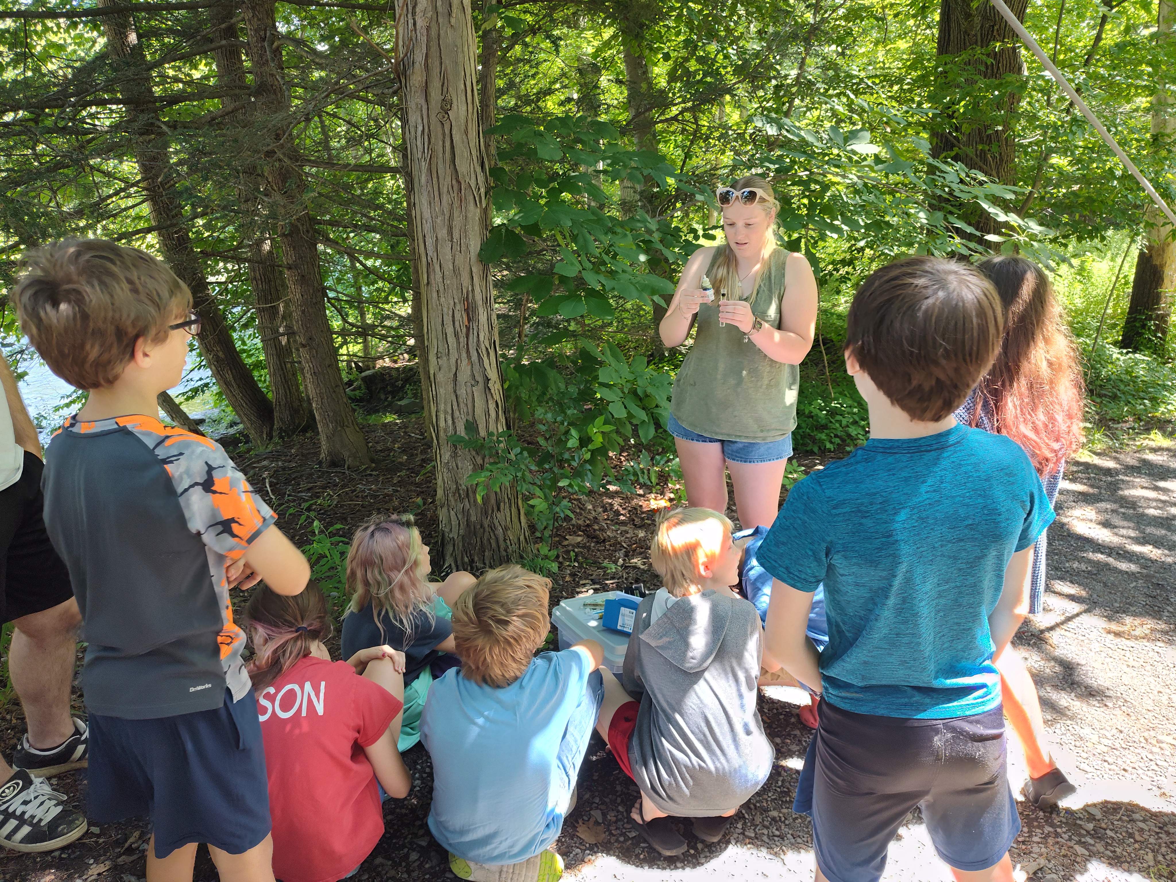 Young girl teaching kids in the woods