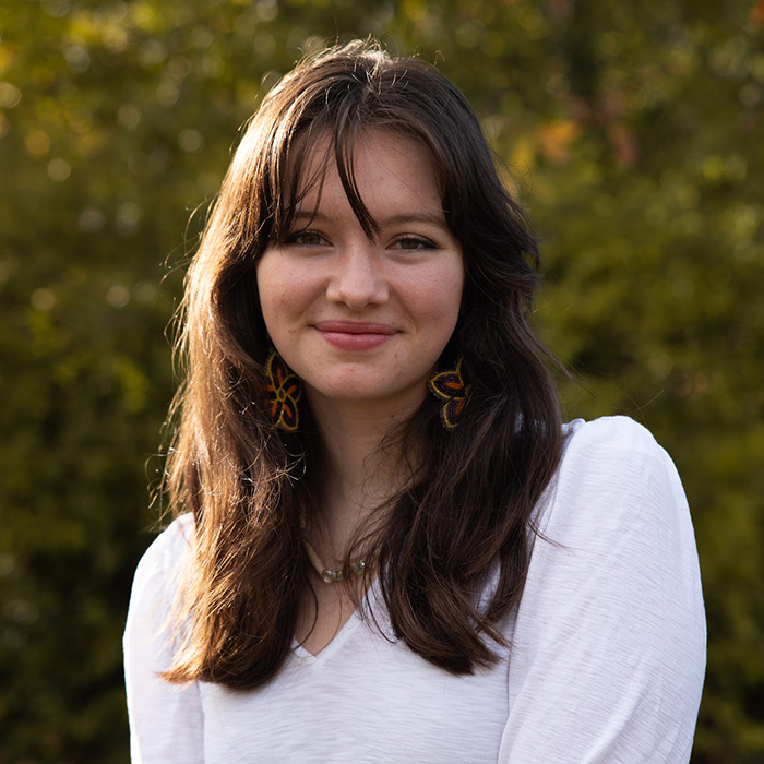 young woman with long brown hair and a whilte shirt