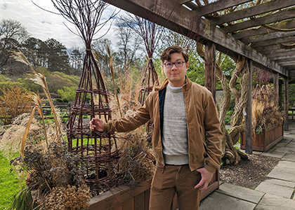 Man standing by willow sculpture in garden