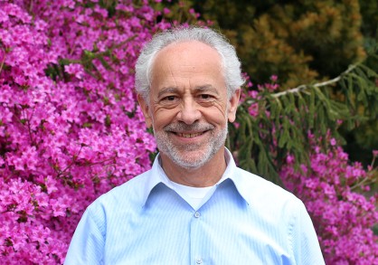 Image of male in front of bring pink rhododendrons