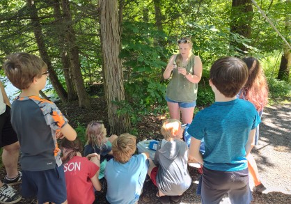 Young girl teaching kids in the woods