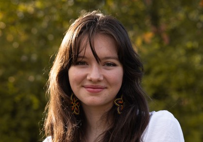 young woman with long brown hair and a whilte shirt