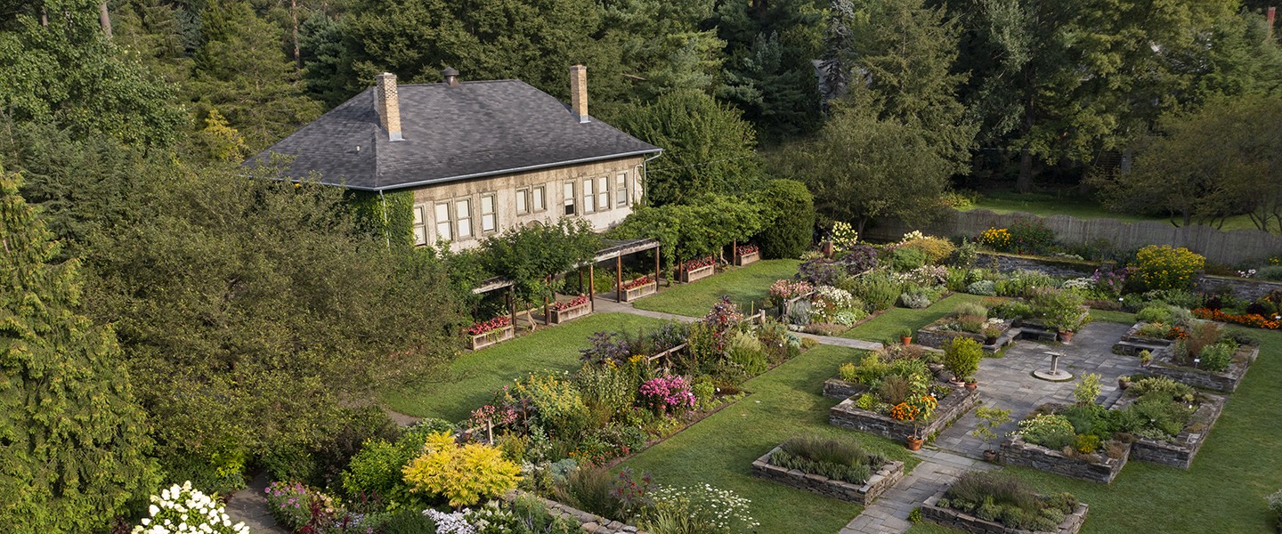 aerial view of small building with beautiful garden surrounding it