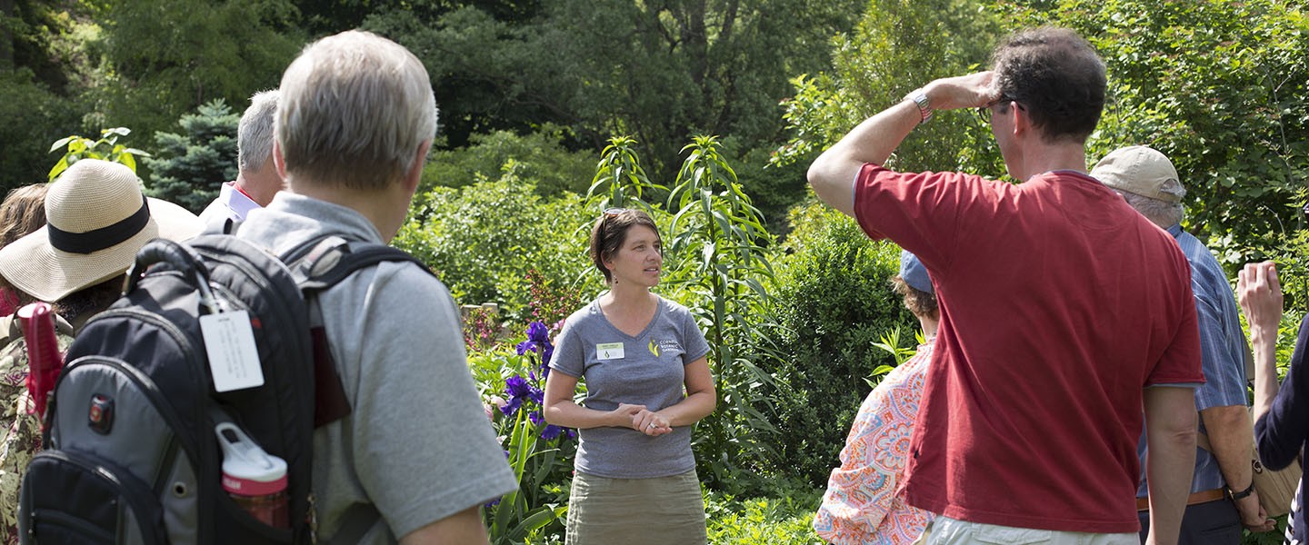 Tour guide talking to a group of people in a garden