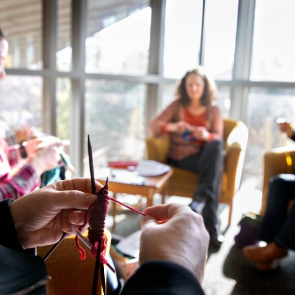 Volunteers sitting in a circle and kitting