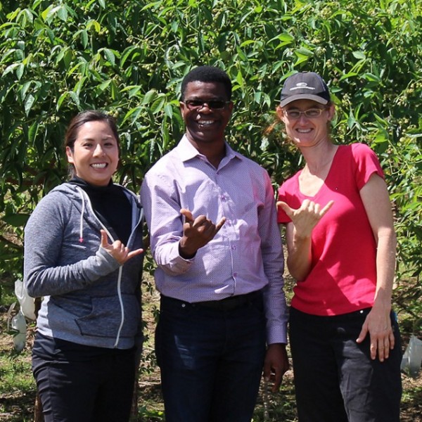 Researchers pose in front of plants