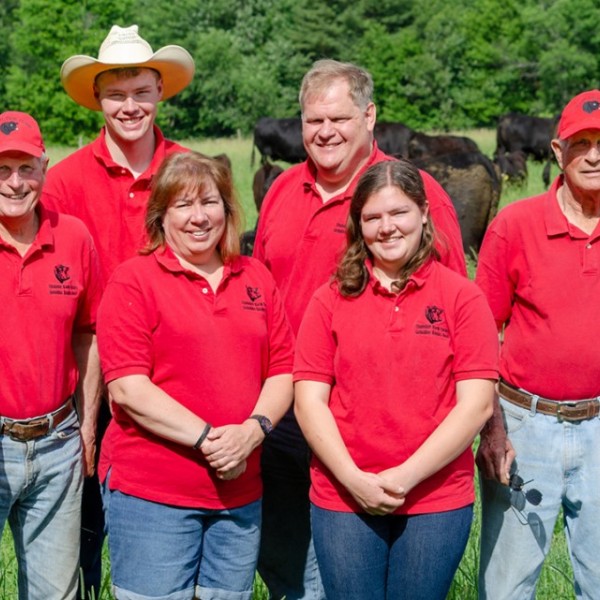 The Coombe family posing in a livestock field 