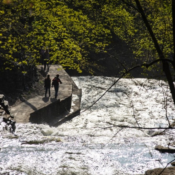 Two people walking on pathway next to gorge