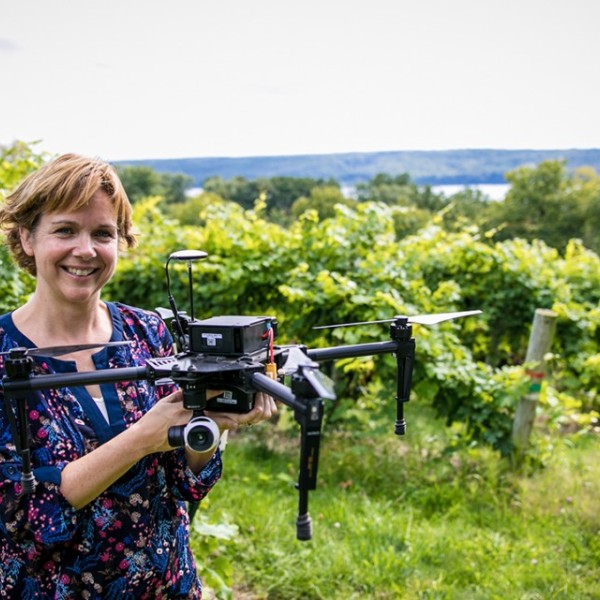 Professor holding a drone in a field