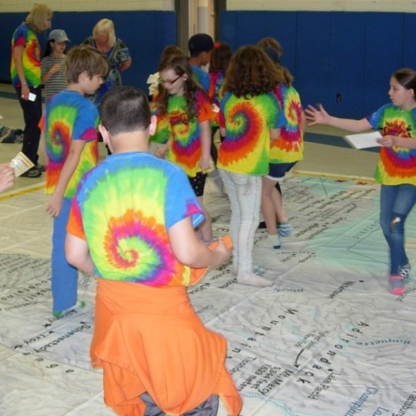 Children standing on top of giant map