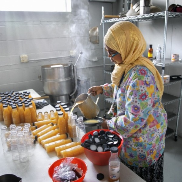 Bisharo Ali prepares bottles of apple fenugreek juice in her commercial kitchen in Buffalo