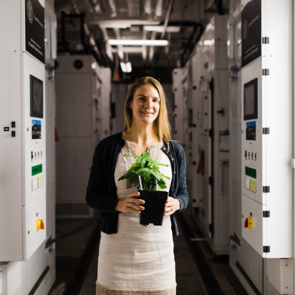 Maragaret Frank in her lab holding a plant