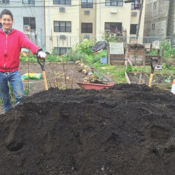 Sara Perl Egendorf standing next to pile of soil