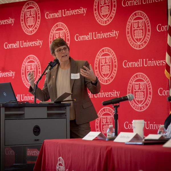 Professor speaking on stage with panel