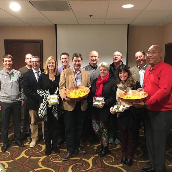 Volunteers standing with food they prepared