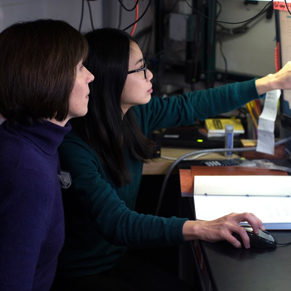 Researchers work at a computer