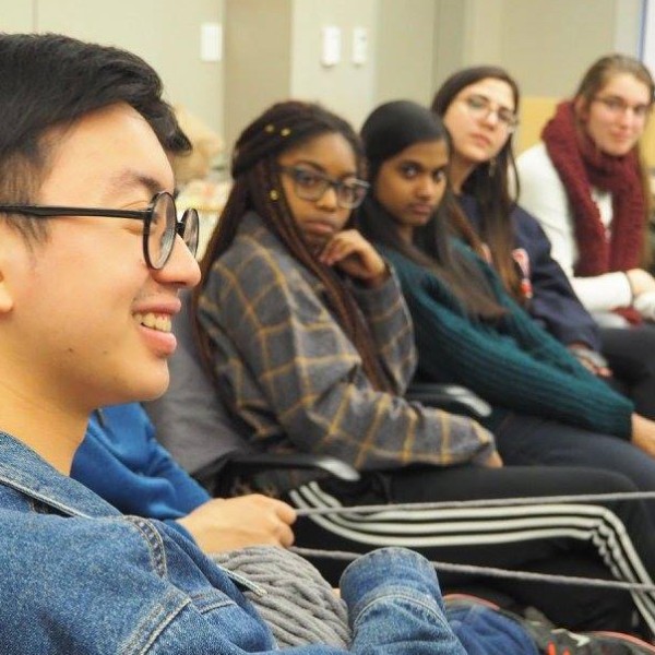 students sit listening to other student