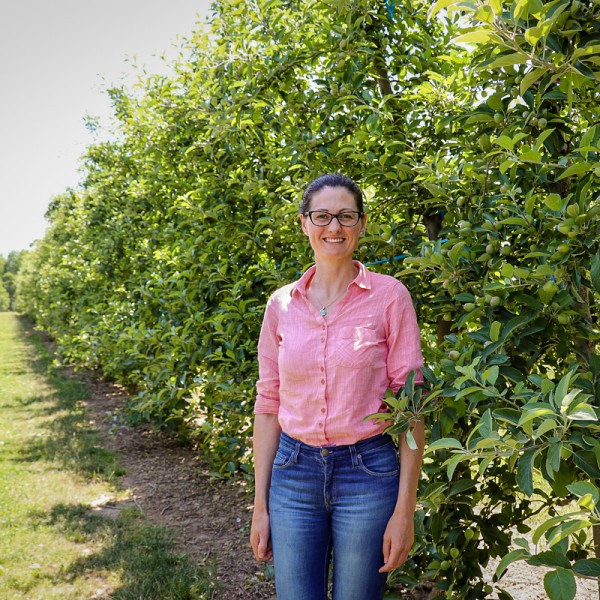 Poliana Francescatto stands in a orchard