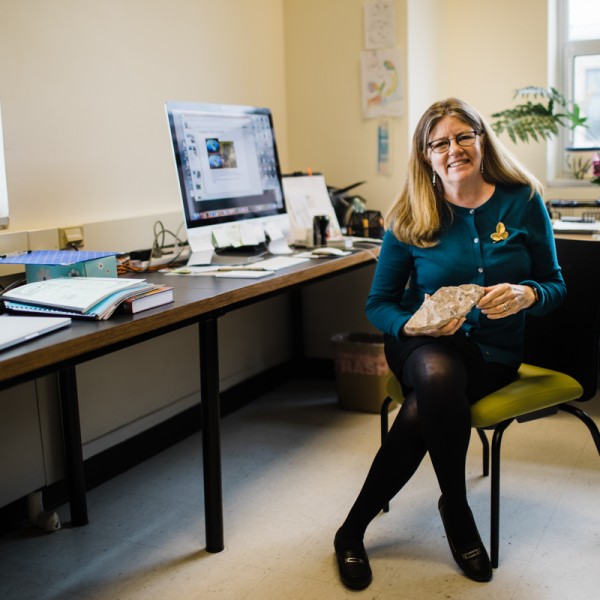 Maria Gandolfo in her office holding a fossil