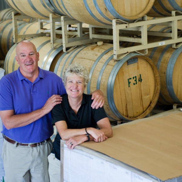 Pete and Tacie Saltonstall stand in front of wine casks