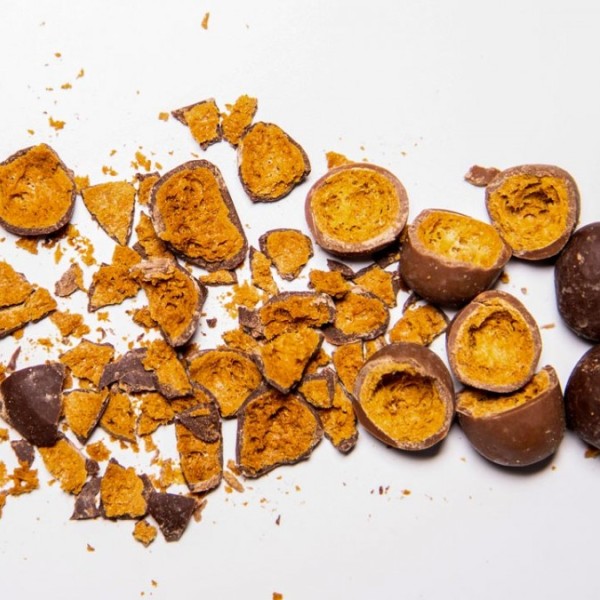 Chocolate covered chickpeas crushed up on a white table 