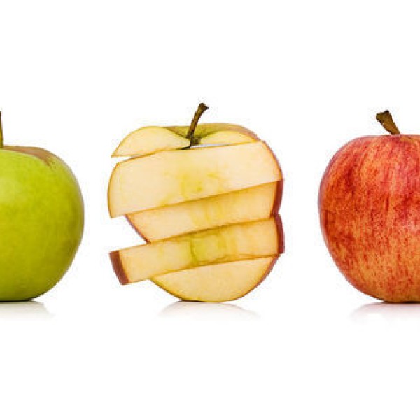 A green apple on the left, a sliced red apple cross-section in the middle, and a red apple on the right