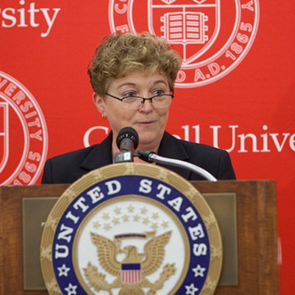 A woman stands at a podium and speaks