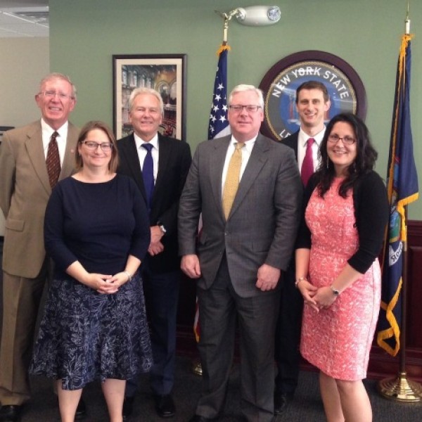 Four men and two women stand together for a photo