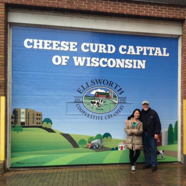A woman and a man standing in front of a cheese curd advertisement