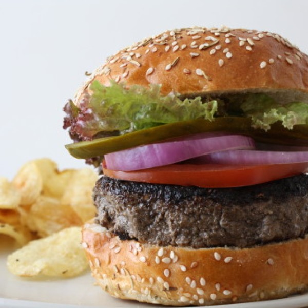 A burger with potato ships on a plate