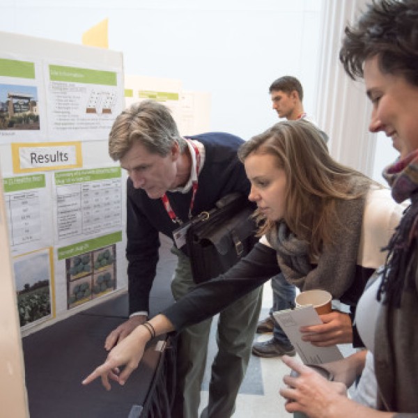 A group of people look at a poster board