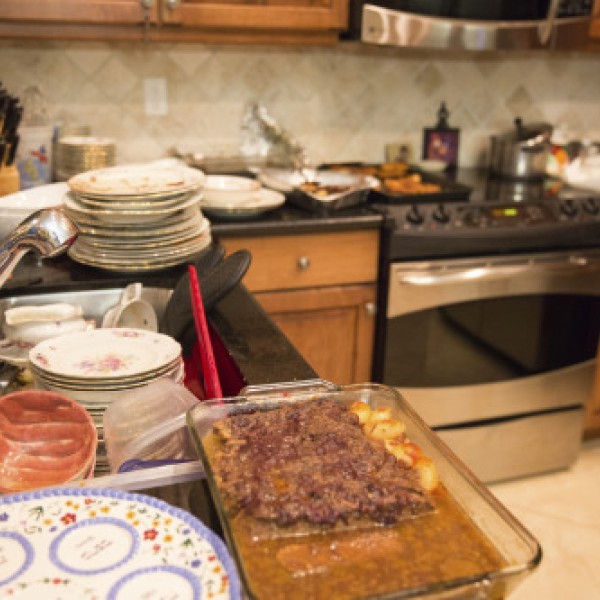 Cluttered kitchen with lots of dirty dishes on the counter