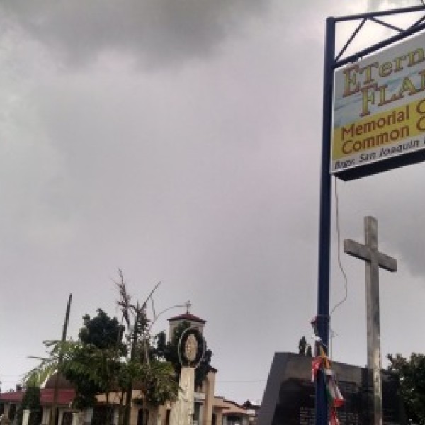 A picture of a "Memorial Garden Common Graves" sign in the Philippines
