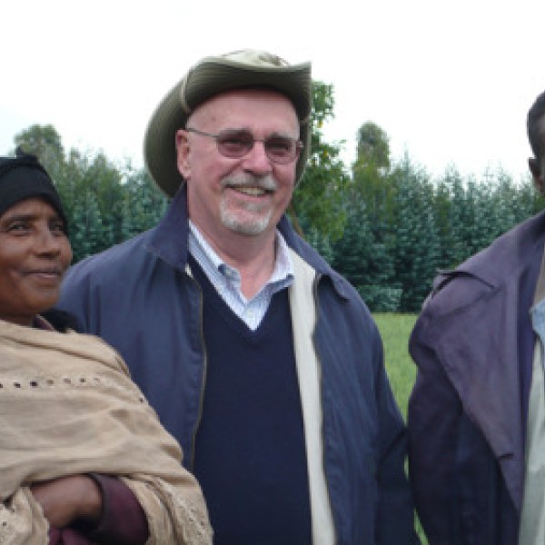Two men and a woman stand in a field in Ethiopia