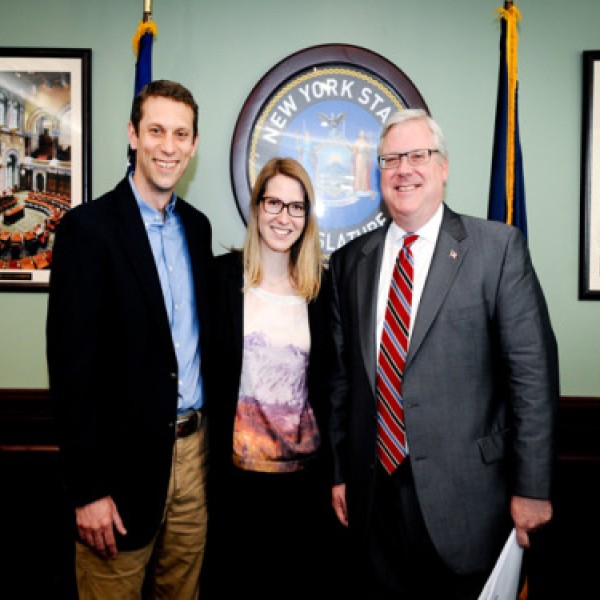 Two men and a woman pose for a picture