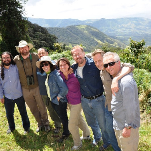 A group of people stand with their arms around each other in the mountains of Ecuador