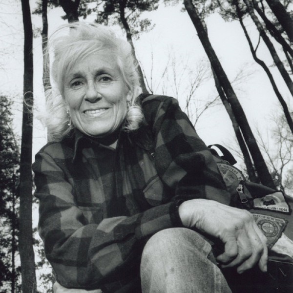 A woman stands in a forest