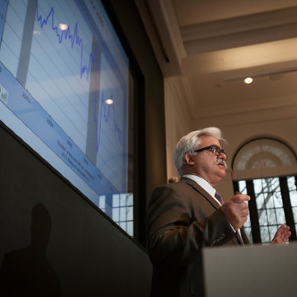 A man gives a presentation while standing at a podium