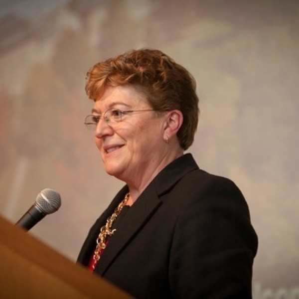 A woman stands at a podium and speaks