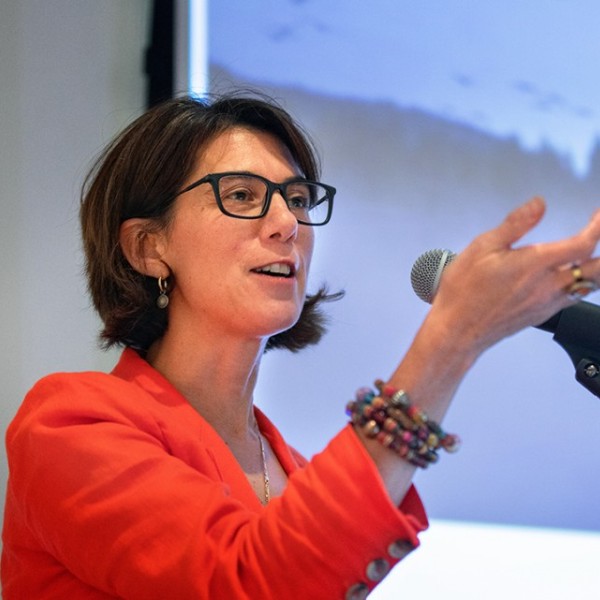A woman standing and talking at a podium.