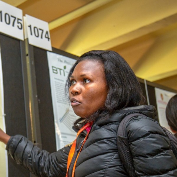 A woman presenting an academic poster to a man 