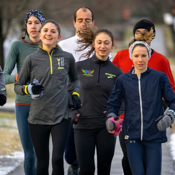 Men and women running down an empty road