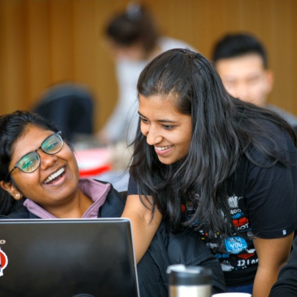 Two female students working together in front of a laptop