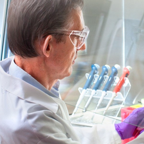 A man working in a lab under a hood