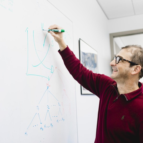 Miguel Gomez draws on a whiteboard.